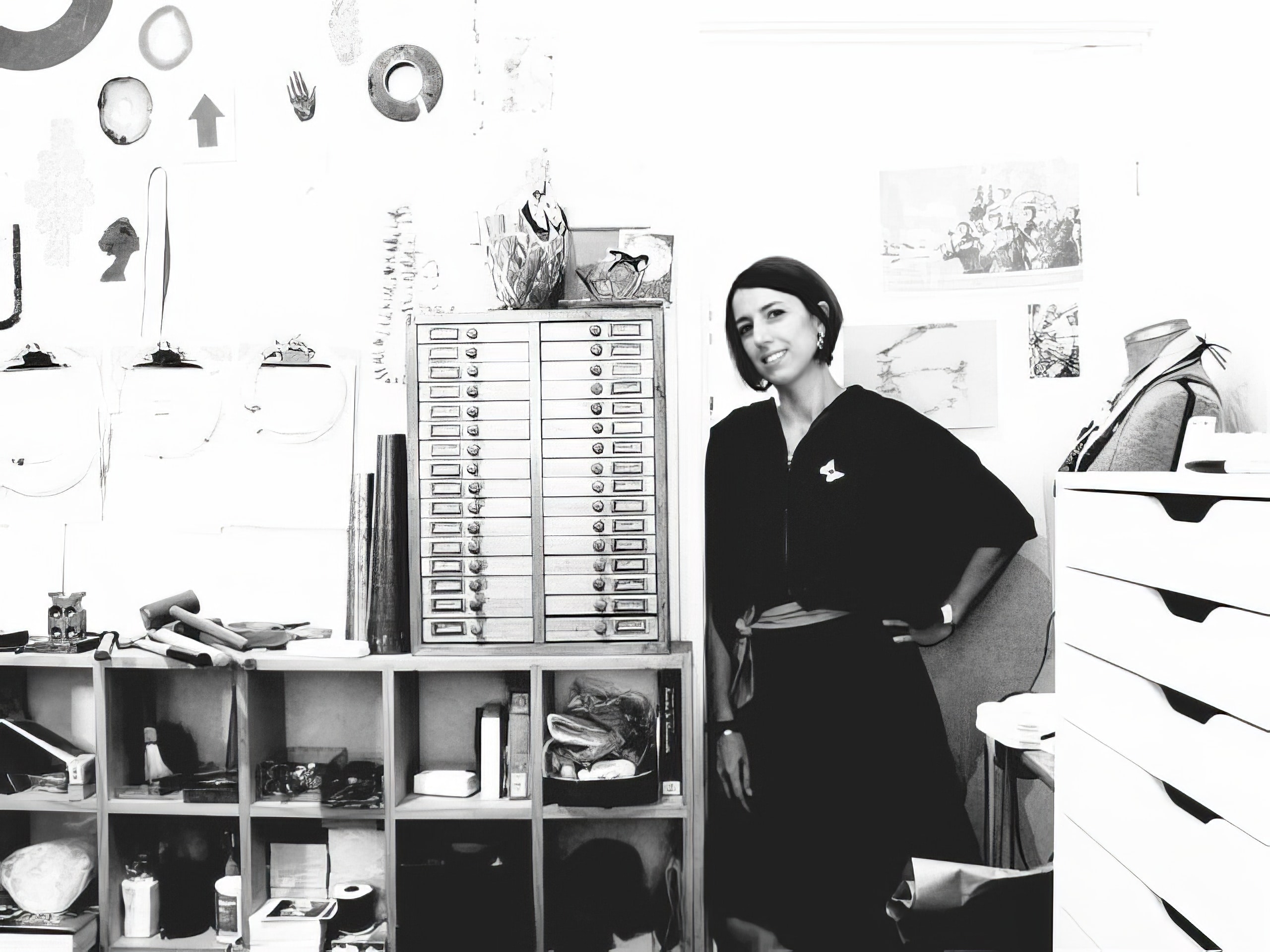 Ari Athans standing in her studio, surrounded by various tooks and artworks.